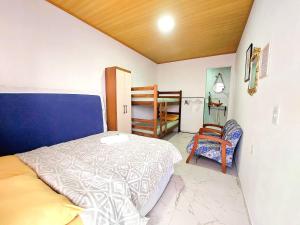 a bedroom with a bed and a chair in it at Aconchego Sol e Mar in Navegantes
