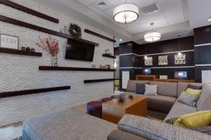 a living room with a couch and a tv at Drury Inn & Suites Huntsville Space & Rocket Center in Huntsville