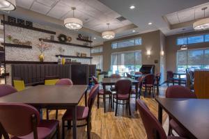 a dining room with tables and chairs and windows at Drury Inn & Suites Huntsville Space & Rocket Center in Huntsville