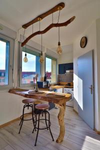 a kitchen with a wooden table and two bar stools at Superbe studio cosy et atypique 3 étoiles in Montbéliard