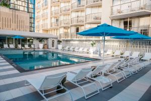 a pool with chairs and umbrellas on a building at OHANA Waikiki East by OUTRIGGER in Honolulu