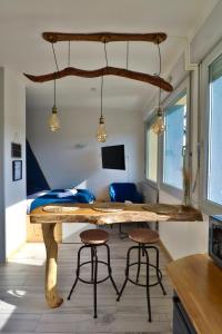 a room with a table with stools and a bed at Superbe studio cosy et atypique 3 étoiles in Montbéliard