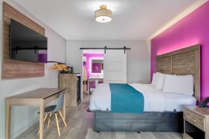 タスカルーサにあるMotel 6 Tuscaloosa AL Universityのベッドと机とテーブルがあるホテルの部屋