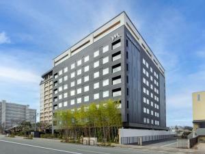 Un edificio alto y negro con un cartel. en Mercure Hida Takayama en Takayama