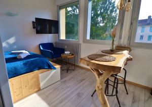 een slaapkamer met een bed, een bureau en een tafel bij Superbe studio cosy et atypique 3 étoiles in Montbéliard