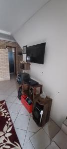 a living room with a flat screen tv on a wall at Sobrado praia cachoeira in Florianópolis
