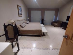 a bedroom with a bed and a couch in it at La Pocilga in Paso de la Patria