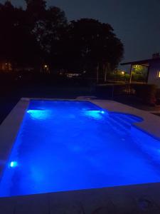a swimming pool with blue lighting at night at La Pocilga in Paso de la Patria