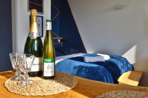 Twee flessen champagne en een glas op tafel. bij Superbe studio cosy et atypique 3 étoiles in Montbéliard