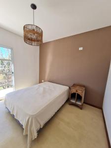 1 dormitorio con 1 cama grande y 1 mesa en Departamentos Mita Í en Isoquí