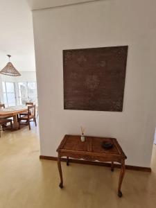 Zimmer mit einem Tisch und einem Gemälde an der Wand in der Unterkunft Departamentos Mita Í in Isoquí
