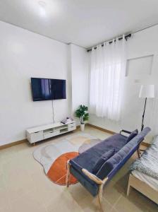 a living room with a couch and a flat screen tv at Ace That Condo Staycation Cheer Residences beside SM Marilao in Marilao