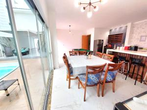 a kitchen and dining room with a table and chairs at Aconchego Sol e Mar in Navegantes