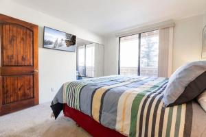 a bedroom with a bed and a large window at Condos with Ski Locker and Vail Mountain Views in Vail