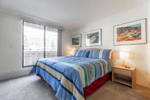 a white bedroom with a bed and a window at Condos with Ski Locker and Vail Mountain Views in Vail
