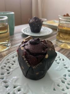 a chocolate muffin sitting on a plate on a table at Indomito Sur Hostel in Punta Arenas