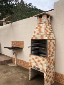 a brick oven on the side of a building at Chalé das Montanhas in Caparaó Velho