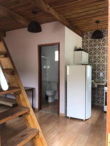 a white refrigerator in a room with a toilet at Chalé das Montanhas in Caparaó Velho