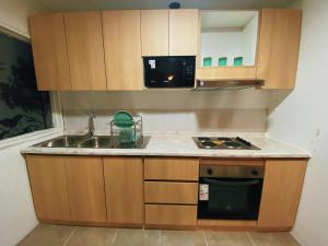 a small kitchen with a sink and a microwave at Indomito Sur Hostel in Punta Arenas