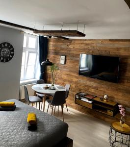 sala de estar con pared de madera y TV grande en Apartament Salvador en Toruń