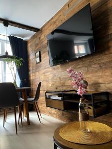 sala de estar con TV en una pared de madera en Apartament Salvador en Toruń