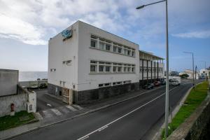um edifício branco na berma de uma estrada em City Glow House em Ponta Delgada