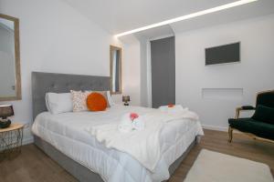 a bedroom with a large white bed with towels on it at City Glow House in Ponta Delgada