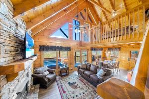 a large living room with a stone fireplace in a log cabin at A Higher Calling, 1089 of FREE area attraction tickets for each paid day, Dollywood and More! in Pigeon Forge