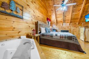 a bedroom with a bed and a tub in a cabin at A Higher Calling, 1089 of FREE area attraction tickets for each paid day, Dollywood and More! in Pigeon Forge
