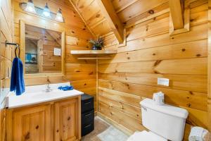 a bathroom with wooden walls and a toilet and a sink at A Higher Calling, 1089 of FREE area attraction tickets for each paid day, Dollywood and More! in Pigeon Forge