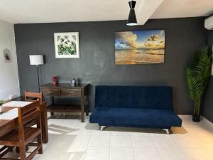 sala de estar con sofá azul y mesa en ALCOBY APARTMENT, en Cancún