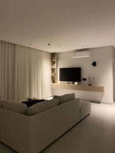 a living room with a couch and a flat screen tv at Elegant 3BD Condo near Boulevard in Riyadh