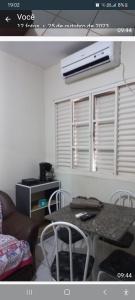 un soggiorno con tavolo, sedie e finestra di Apartamento mobiliado - Centro Cuiabá a Cuiabá