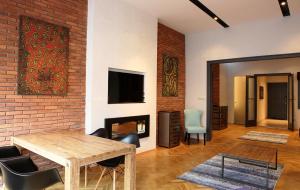 a living room with a table and a brick wall at New Design Apartment - Fashion Street in Budapest