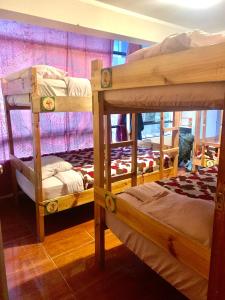 a room with three bunk beds in it at Namaste House in Cusco