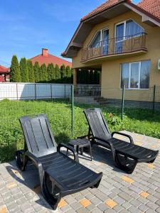 two black chairs sitting in front of a house at NEW апартаменты на Гвардейской in Uzhhorod