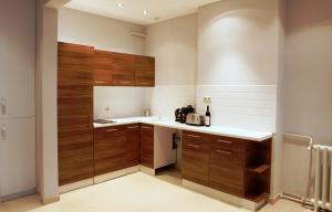 una cocina con armarios de madera y encimeras blancas en New Design Apartment - Fashion Street, en Budapest