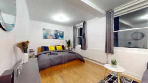 a small bedroom with a bed and a window at Spacious Duplex Apartment in London
