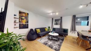 a living room with a couch and a table at Spacious Duplex Apartment in London