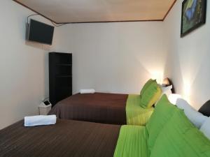 Habitación de hotel con 2 camas y TV en Hotel Santa Fe B&B, en Monteverde