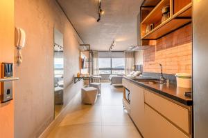 uma cozinha com um balcão e uma sala de estar em LIV Apartamento 1705 em Porto Alegre