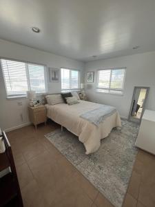 ein Schlafzimmer mit einem großen Bett in einem Zimmer mit Fenstern in der Unterkunft Kailani Loft, Kailua Coconut Grove 1-bedroom in Kailua