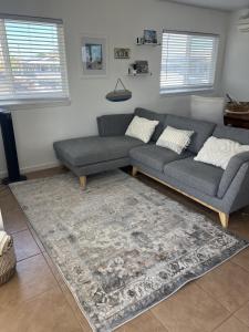 a living room with a couch and a rug at Kailani Loft, Kailua Coconut Grove 1-bedroom in Kailua