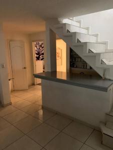 una sala de estar con una escalera blanca en una casa en Casa completa para 8 en Coacalco SuperB en Ciudad de México