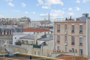 a view of a city with buildings and the eiffel tower at Luminous penthouse with a view in Paris - Welkeys in Paris