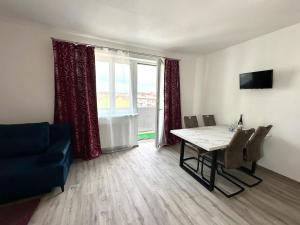 a living room with a table and a couch and a window at Sky Apartments 501 in Pilsen