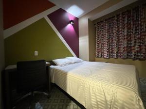 a bedroom with a bed and a desk and a window at Moon Hotel Brooklyn in Brooklyn