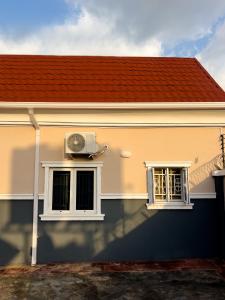 a house with a fan and two windows at Cozy Apartment - Hideaway with 5G WiFi in Abuja