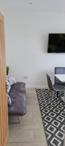 a living room with a couch and a table at SHM Stays Leicester. Newly Renovated!! 15 min drive from City Centre, University. 9 min Drive to Leicester City Stadium, 5 min drive to M1 & M69. 2 min walk to bus stop. in Leicester