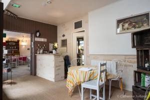 a room with a table and chairs and a kitchen at Hotel Phoebus in La Tremblade